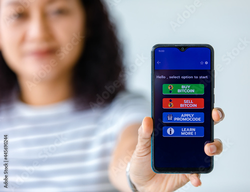 Woman holding and show screens of smartphones with buttons for buying and selling in an application for bitcoin or cryptocurrency digital money trading photo