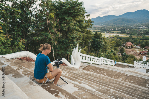 Man photographer sitting on Stairs at Big Buddha viewpoint at sunset time photo