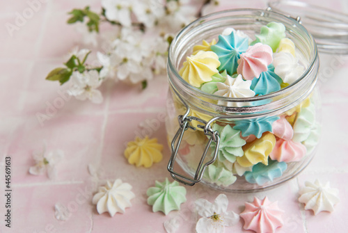 Small colorful meringues in the glass jar