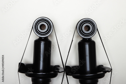 The upper mountings of the shock absorbers for the machine lie on a flat surface. A set of spare parts for the repair of the chassis of the vehicle. Details on white background, copy space available photo