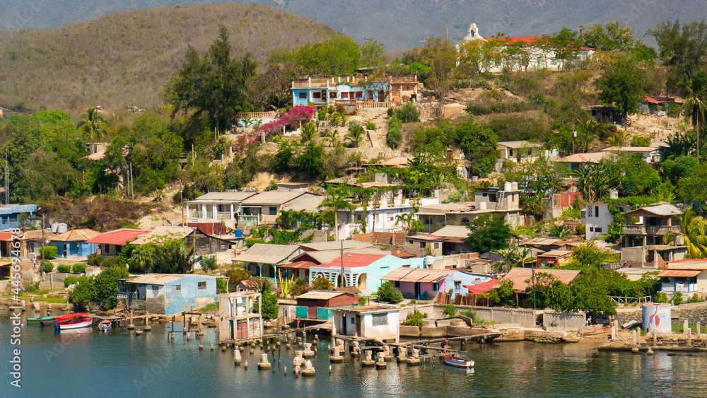 Cuban poor colorful village with church on the hill near city Santiago de Cuba  