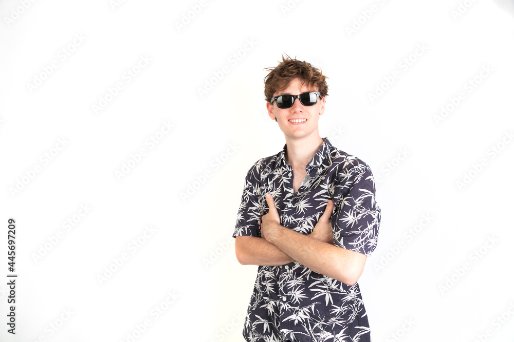 Teenager with sunglasses looking at camera smiling with his arms crossed  portrait, white background, 18-20 years old. White european guy. Stock  Photo