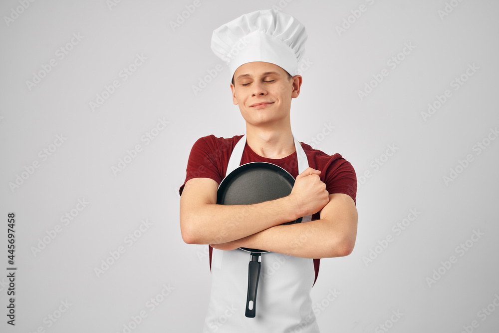 chef in uniform Frying pan in the hands of a professional restaurant kitchen chef in uniform Frying pan in the hands of a professional restaurant kitchen