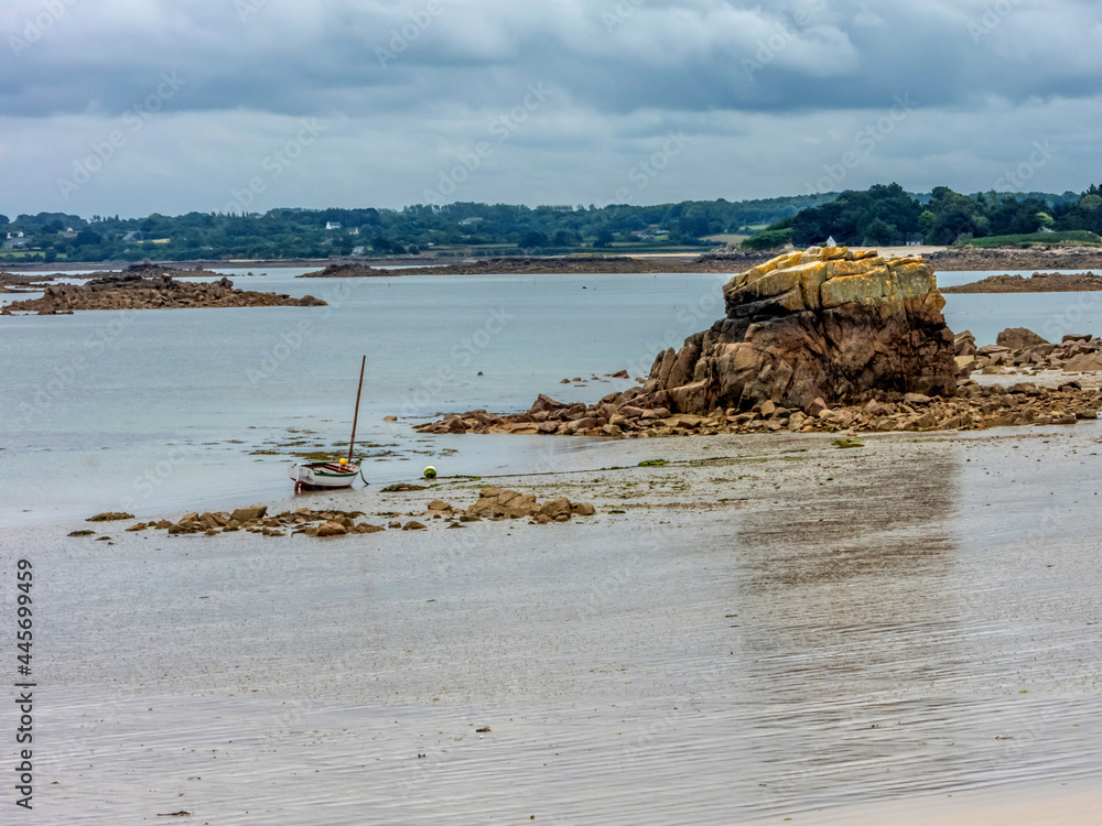 Bateau de pêche couché à marée basse sur une plage en Bretagne