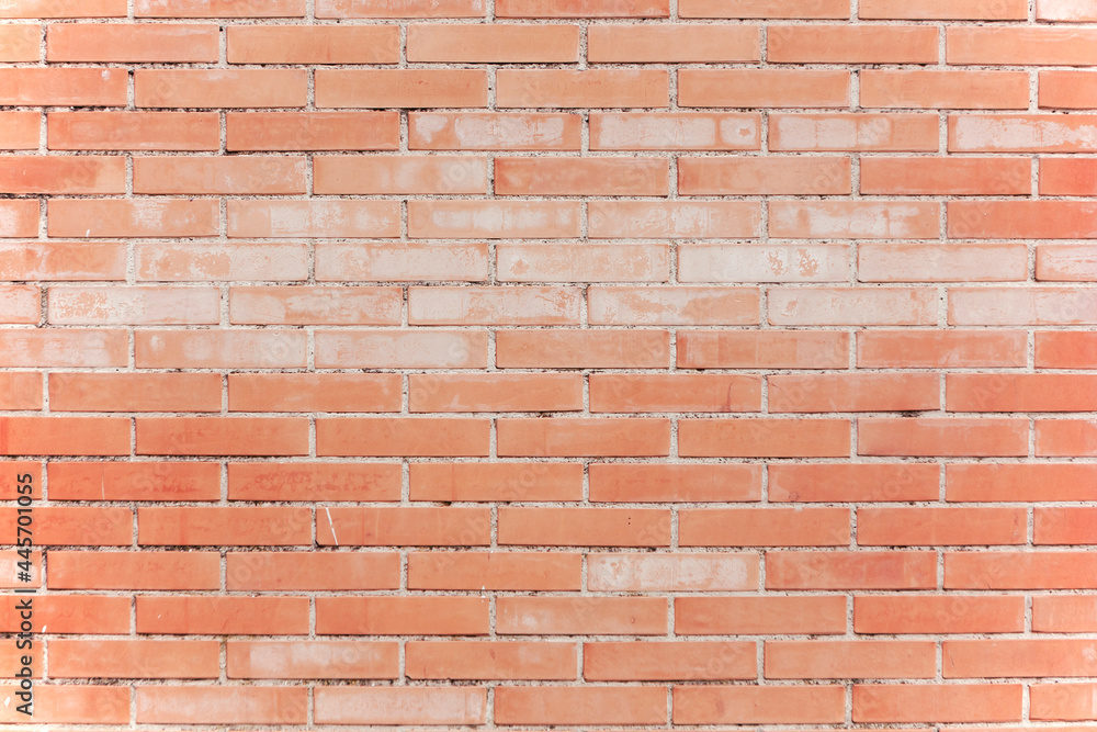 Obraz premium A wall of worn red bricks, with the remnants of some cement. Useful backdrop texture, tenuous faded colors. 