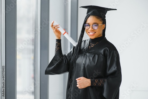 happy african american female student with diploma at graduation