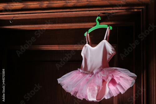 pink small tutu for baby hanging over a wooden door