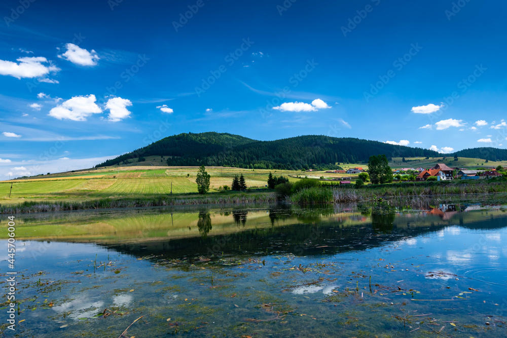 Fototapeta premium Sumuleu mountain reflecting in a small pond in Miercurea Ciuc, Romania, one of the most visited places by pilgrims in Eastern Europe.
