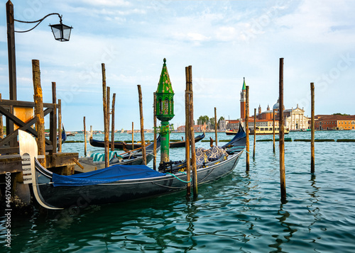 Beautiful view of traditional Venetian gondola moored by jetty and floating on waters of Grand Canal in Venice, Italy. Tourist attraction, destination