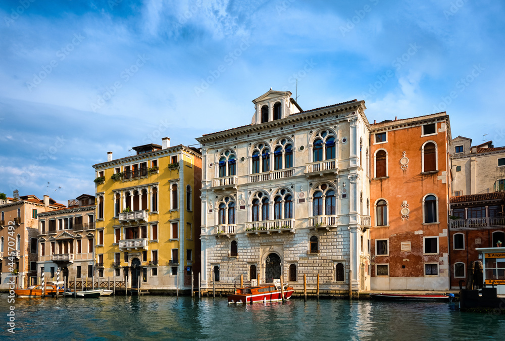 Classic view of Venetian landscape. Waterfront palace or palazzo of Renaissance era and a boat moored by it. Grand Canal, Venice, Italy.