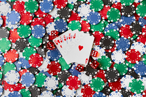 Casino chips, playing cards and dices on green fabric table