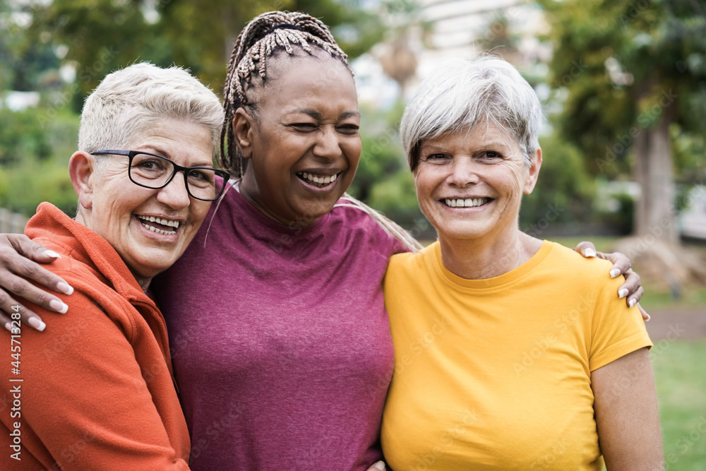 Multiracial senior women having fun together after sport workout outdoor - Focus on left female face Multiracial senior women having fun together after sport workout outdoor - Focus on left female face