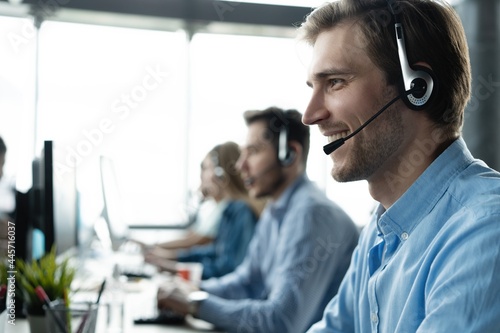 Young handsome male customer support phone operator with headset working in call center