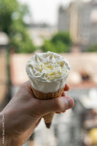 Sweet tasty ice cream corn with white chocolate in hand on a hot sunny day in summer