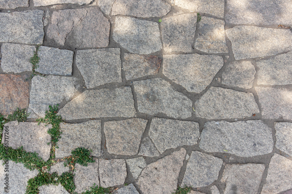 Stone paving stones on the sidewalk old road made of stone Stone paving stones on the sidewalk old road made of stone