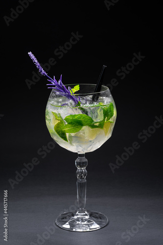 cocktail hugo or mojito with mint, lime and ice in wineglass on black background
