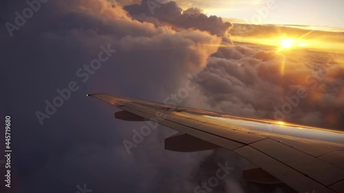 Aerial view of sunrise through airliner window in the morning. Aerial view of Cloudscape in dawn through plane window. Beautiful trip and good transportation with the plane concept.