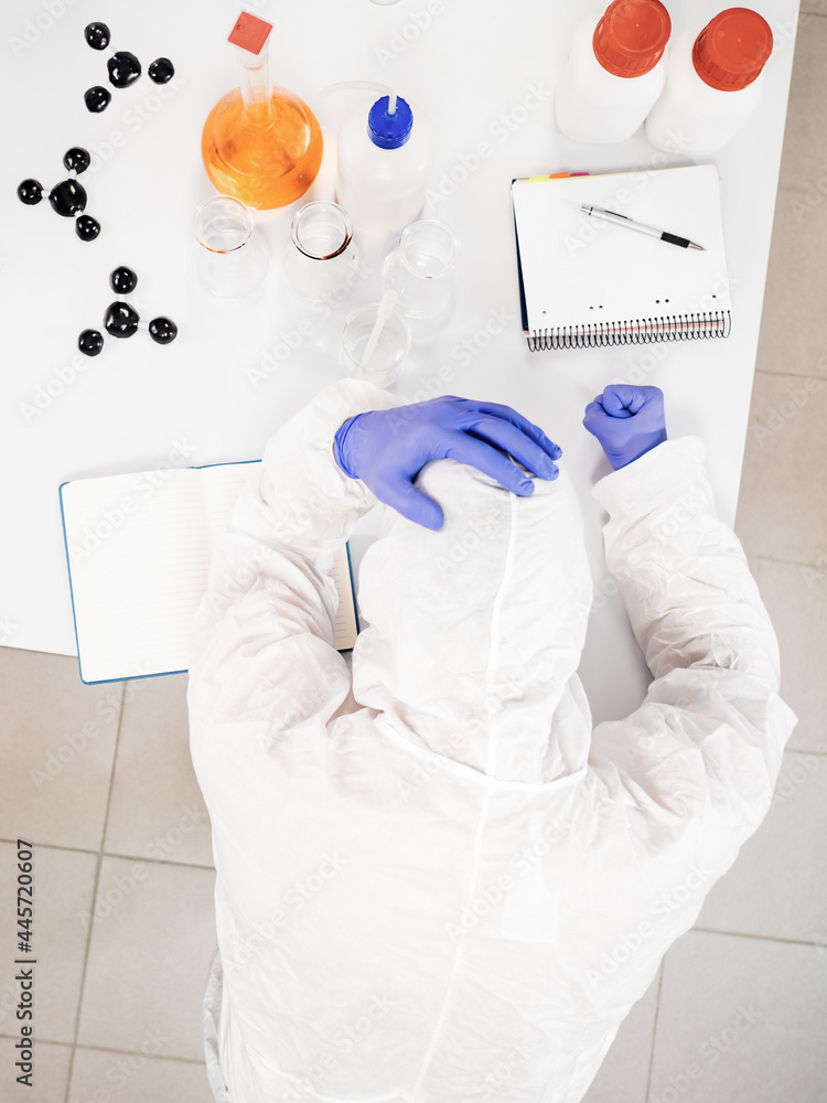 Fototapeta premium Top view of a stressed scientist on the lab table.
