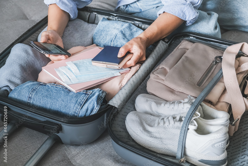 Travel. Online travel plans with Covid passport and Covid test. Traveling after quarantine, lockdown, covid 19. Staycation.local travel new normal.Girl packs baggage in suitcase and travel documents