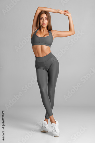 Beautiful fitness woman on gray background