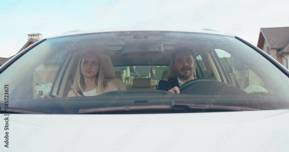 Cheerful caucasian couple in love sitting in car, moving in rhythm. Young people having fun together. Waving hands. Good mood. Enjoy. Car's interior. Cheerful caucasian couple in love sitting in car, moving in rhythm. Young people having fun together. Waving hands. Good mood. Enjoy. Car's interior.