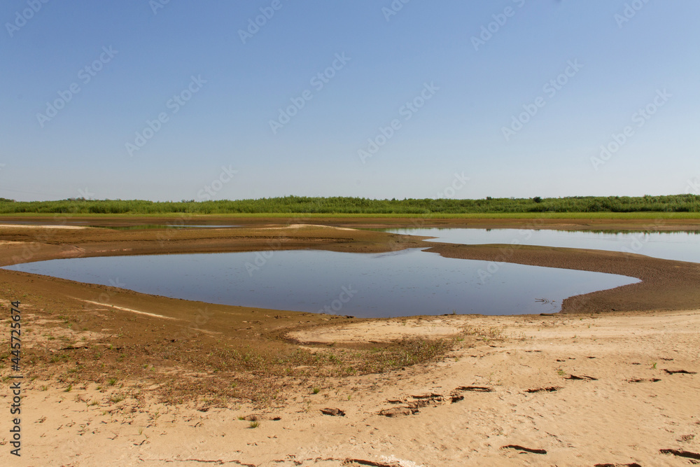 natural background with a river lagoon, a sandy shore and a horizon
