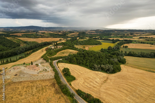 Beautiful idyllic summer or autumn landscape of Toscana with hills, forest trees and agricultural fields. Quiet cloudy evening before the rain in Italy. Agricultural fields of Tuscany 