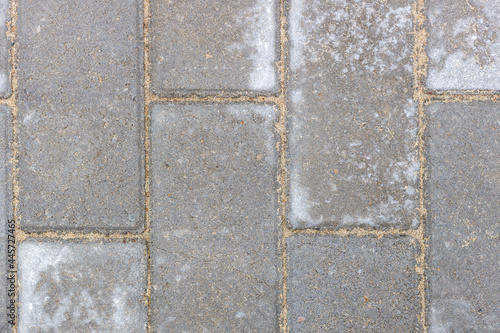 Gray texture of paving stones. Close-up of stone tiles for sidewalks. Top view