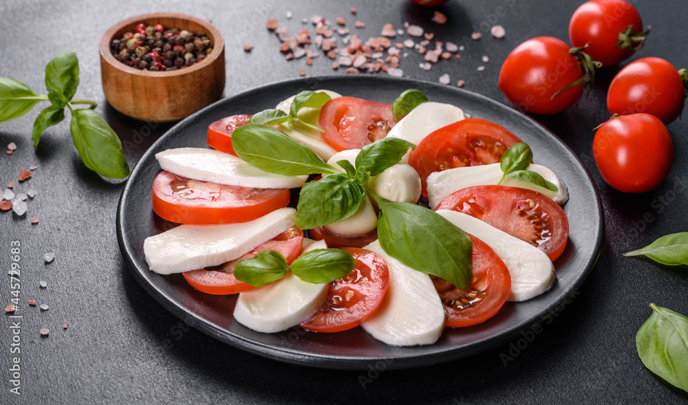 Italian caprese salad with sliced tomatoes, mozzarella cheese, basil, olive oil Italian caprese salad with sliced tomatoes, mozzarella cheese, basil, olive oil