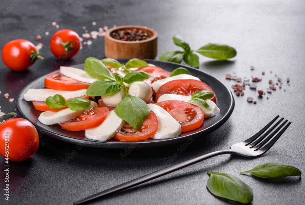 Italian caprese salad with sliced tomatoes, mozzarella cheese, basil, olive oil