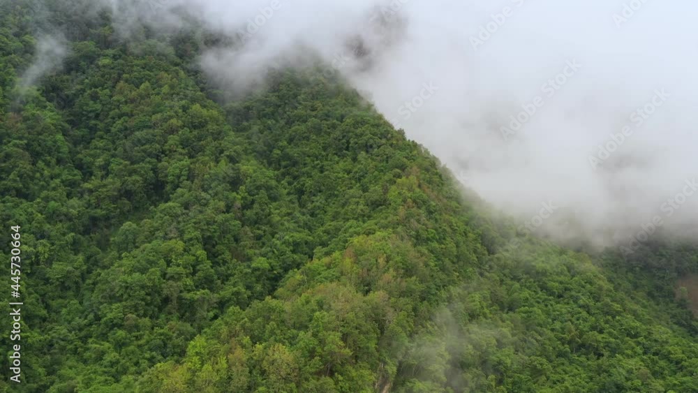Aerial view flying above lush green tropical rain forest mountain with rain cloud cover during the rainy season on the Doi Phuka Mountain reserve national park. In, the northern Thailand Aerial view flying above lush green tropical rain forest mountain with rain cloud cover during the rainy season on the Doi Phuka Mountain reserve national park. In, the northern Thailand