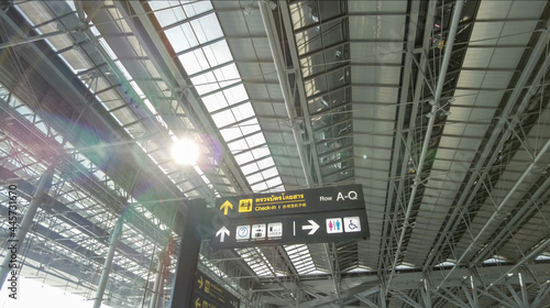 Abstract business background of Thailand international airport, the photo compose of the sign of check-in counter and tourist information in trilingual and structural roof with flare of sunlight.
