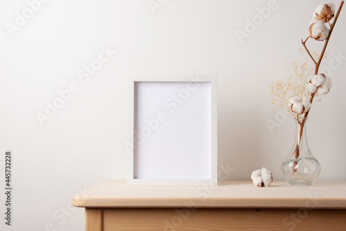 Fototapeta Naklejka Na Ścianę i Meble -  Home decoration with white mock up frame on table. Artwork showcase. Scandinavian style, copy space