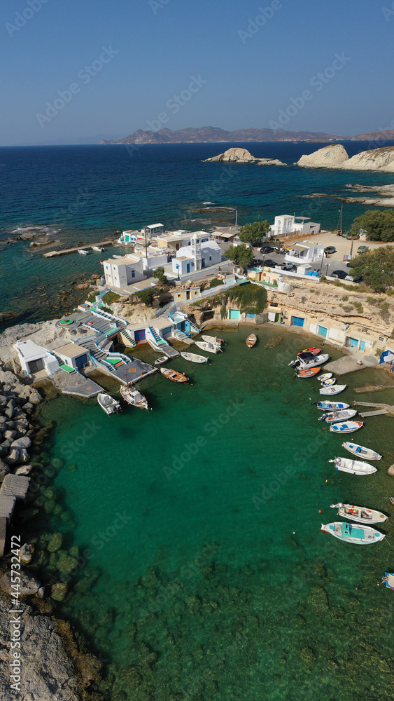Aerial drone photo of picturesque small fishing harbour of Mandrakia with traditional boat houses called syrmata and anchored fishing boats, Milos island, Cyclades, Greece