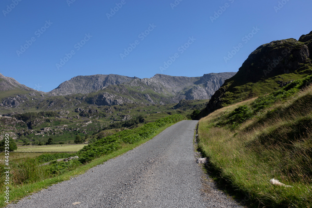 Rural road in the Nant Ffrancon Valley part of the Snowdonia National Park, North Wales.  On a summers day with blue sky.