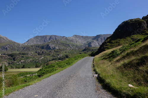 Rural road in the Nant Ffrancon Valley part of the Snowdonia National Park, North Wales. On a summers day with blue sky.