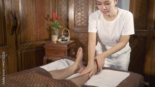 Young woman terapist doing a foot massage to a guest photo