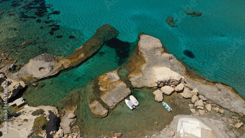 Aerial drone view of iconic volcanic white chalk sandy organised with sun beds and umbrellas beach of Firiplaka with turquoise clear sea and rocky colour formations, Milos island, Cyclades, Greece photo