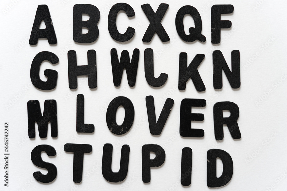 alphabet arranged with cryptic message (lover stupid) in black chalk letters on a white background alphabet arranged with cryptic message (lover stupid) in black chalk letters on a white background