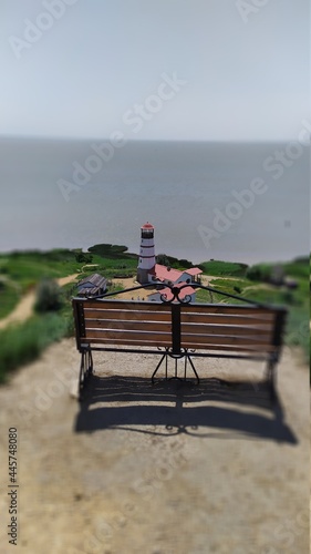 a bench looking at the lighthouse and the sea