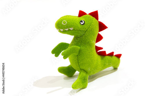 Green plush dinosaur doll, isolated on white.