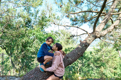 Brother and sister on a tree, sibling's love concept © Novodiastock