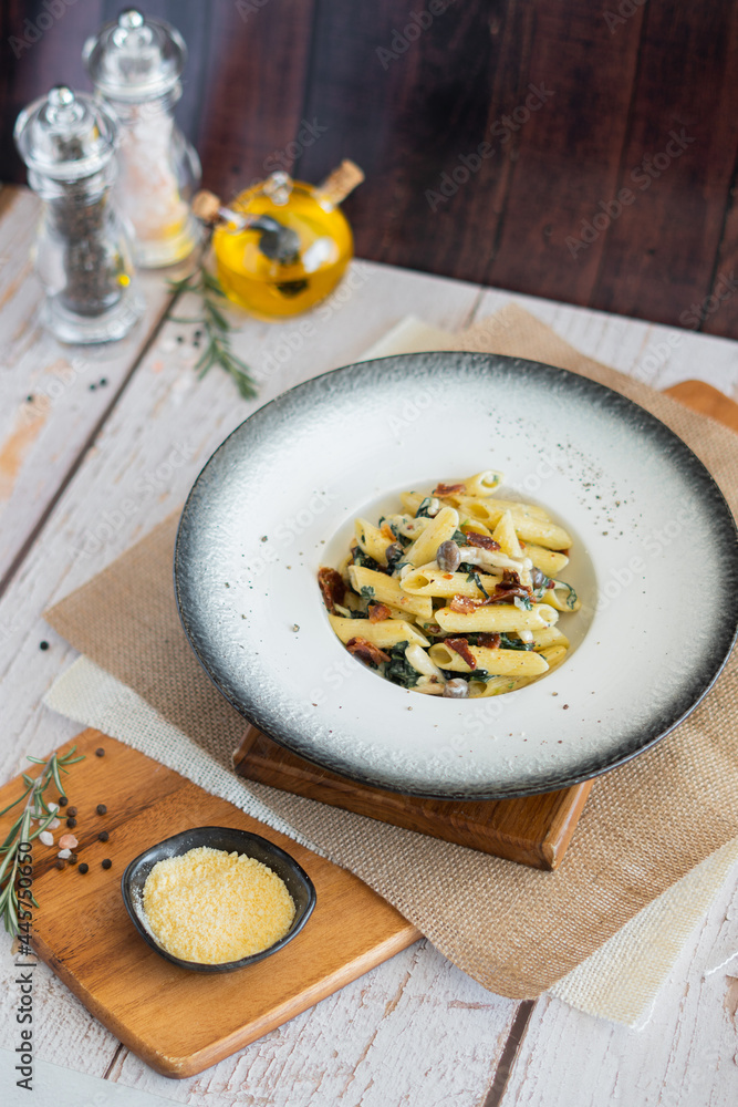 Penne mushroom with Cream Sauce and spiach bacon on wooden board Penne mushroom with Cream Sauce and spiach bacon on wooden board