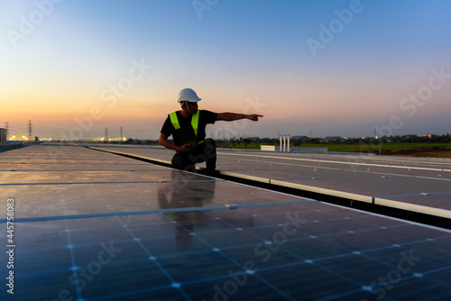 Technician checking Photovoltaic cells panels on factory roof  Maintenance of the solar panels  Engineer service  Inspecor concept. Silhouette Photo.