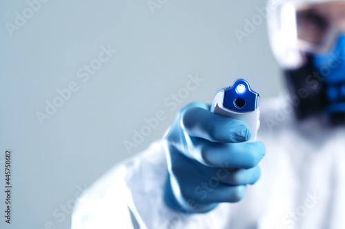 image of an electronic thermometer in the hands of a doctor .