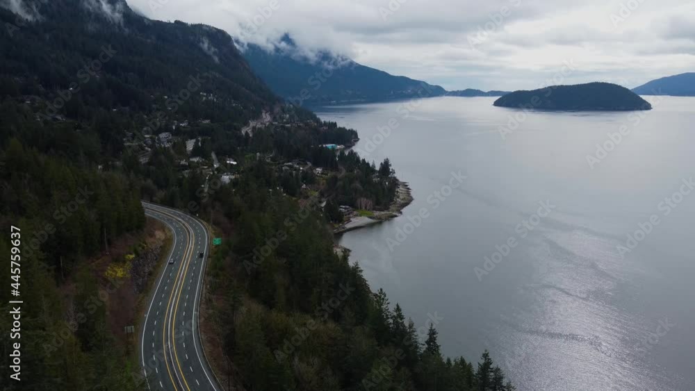Aerial view of neighbourhood and s-shaped highway between mountain and bay Aerial view of neighbourhood and s-shaped highway between mountain and bay