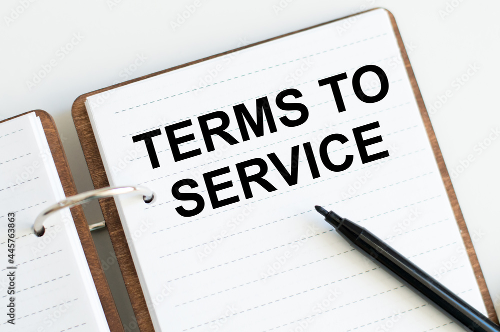 Terms to service inscription on an open notebook with a black marker on a white background Terms to service inscription on an open notebook with a black marker on a white background