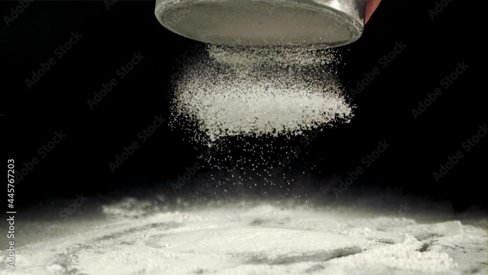 Super slow motion for baking flour is sifted through a sieve. On a ...