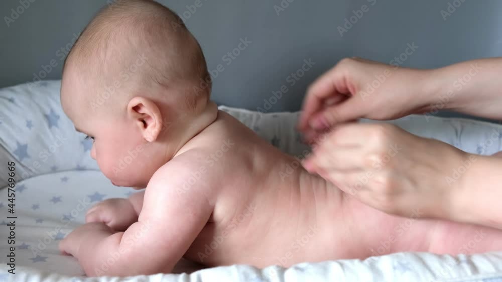 Mother Giving Back Massage To Little Child. Closeup. Mom Gives massage To Infant Baby. Prevention of Tremor. Female Hands Gently Massaging To Newborn Naked Body. Smears with Cream, Body care concept. Mother Giving Back Massage To Little Child. Closeup. Mom Gives massage To Infant Baby. Prevention of Tremor. Female Hands Gently Massaging To Newborn Naked Body. Smears with Cream, Body care concept.