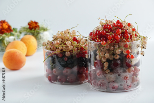 Berries in a glass bowl on a background of peaches